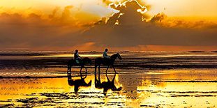 Balade romantique à cheval au coucher du soleil sur la plage